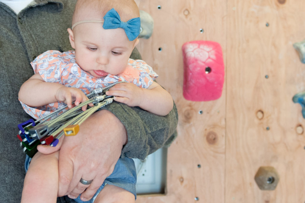 Emma playing with rock climbing tools