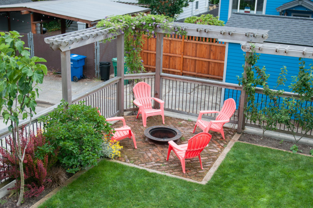 Seattle backyard fire pit with four red lawn chairs