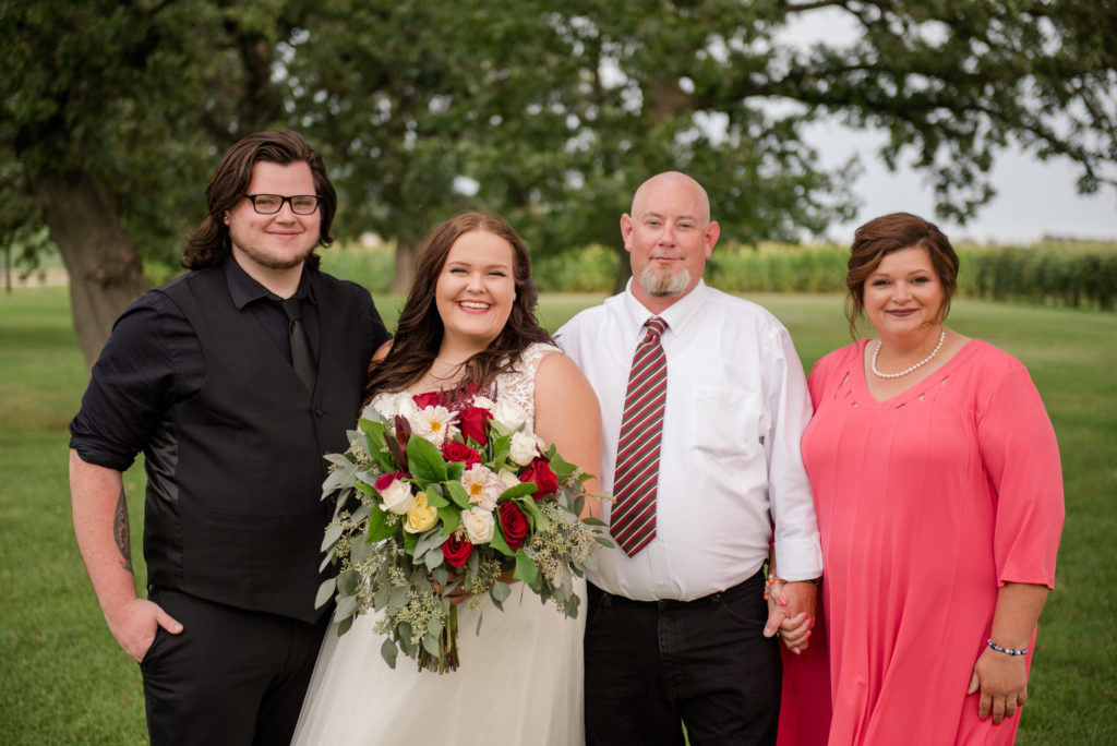 Jesse & Paige McEachran Homestead Winery outdoor wedding bride and groom with groom's parents by Tina Captures Photography