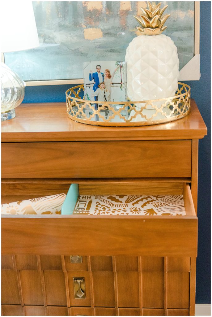 Wallpapered drawers, gold accent decorations, pineapple decor. Designed by McFadden & Grace. Tina Captures Photography.