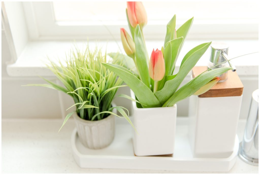 Kitchen counter details red tulips, soap dispenser and plant. Designed by McFadden & Grace. Tina Captures Photography.