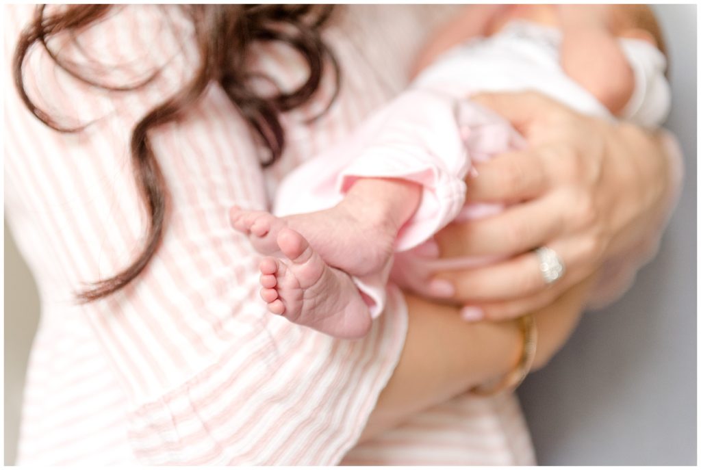 Close up of baby's feet while being held in mom's arms during orange county in-home newborn photography session