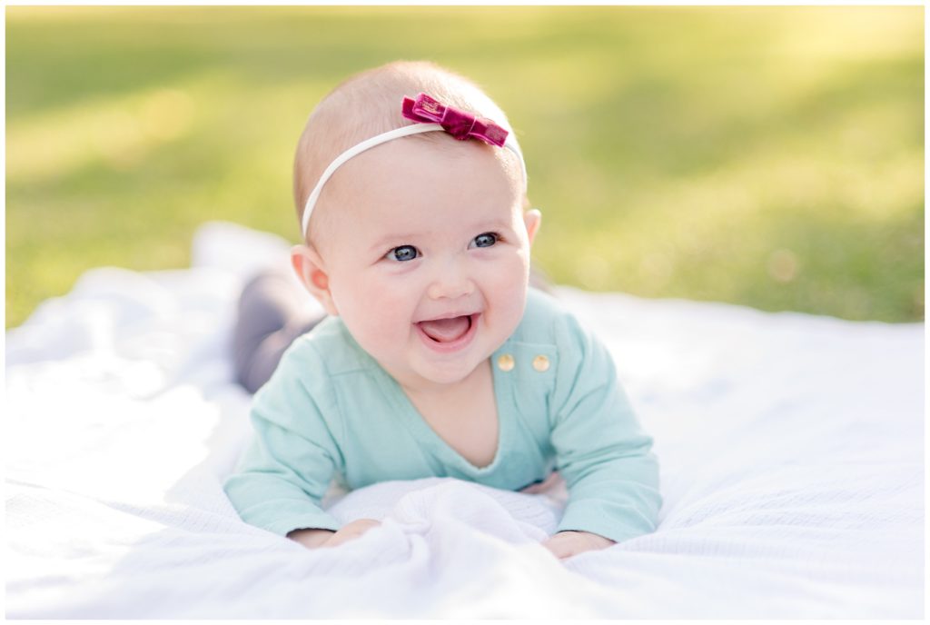 Baby laying on a picnic blanket outside during orange county family photography ÷÷÷÷÷session